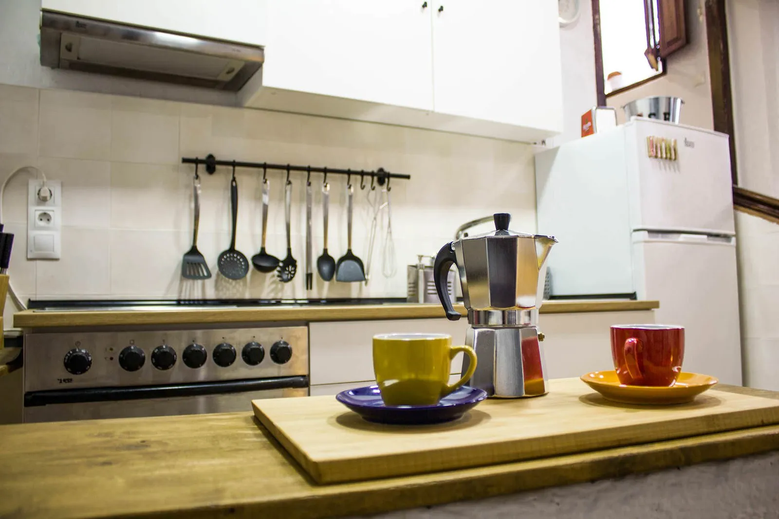 Encimera de la cocina con cafetera italiana y tazas de colores
