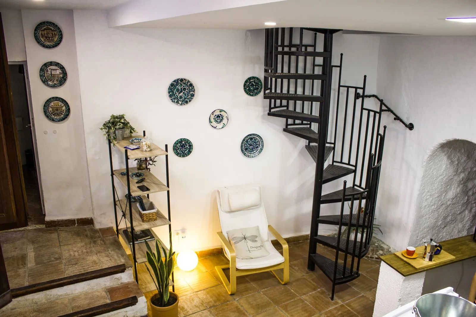 Escalera de caracol y platos de cerámica granadina en la pared