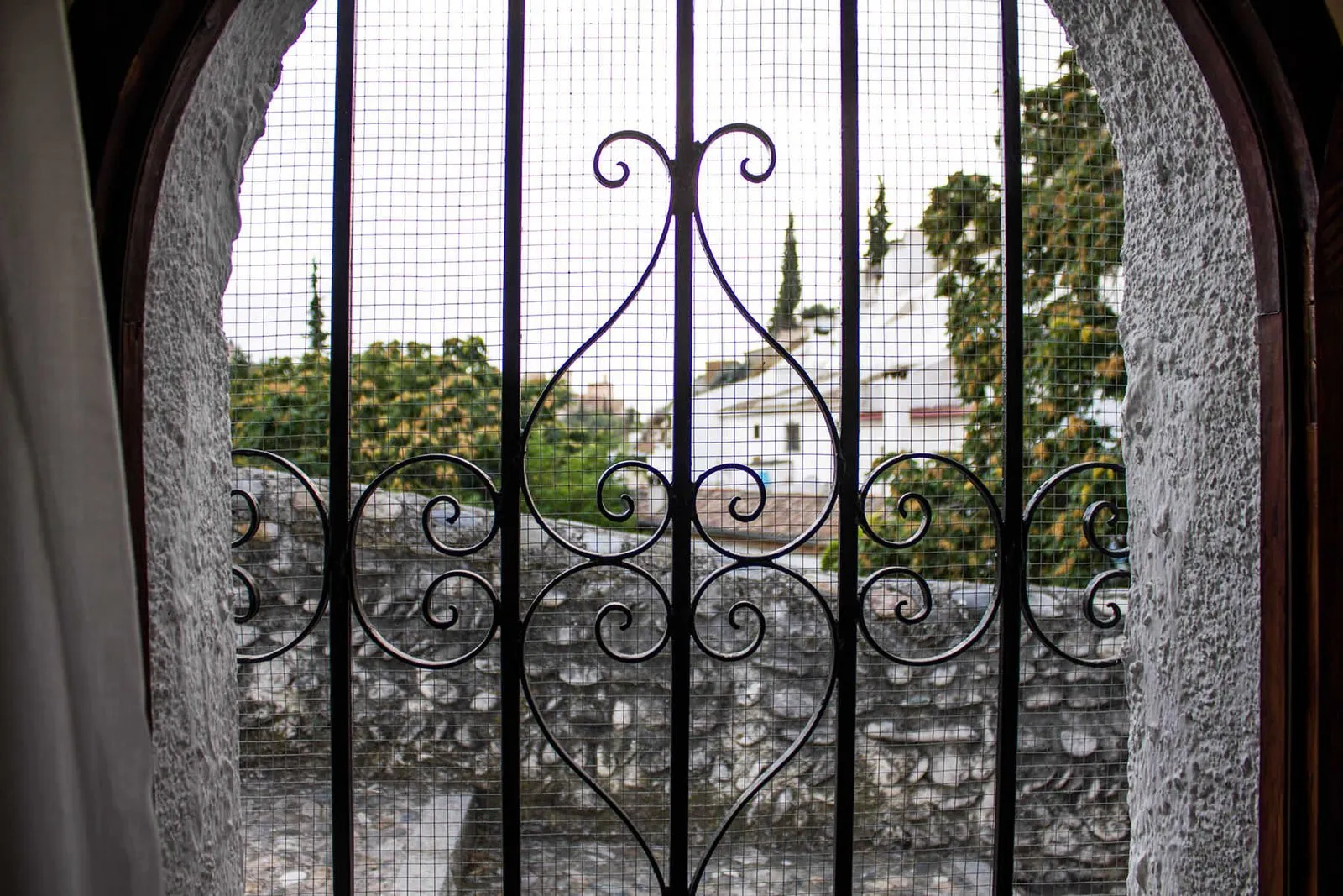 Ventana con reja de forja y vistas al barrio del Sacromonte